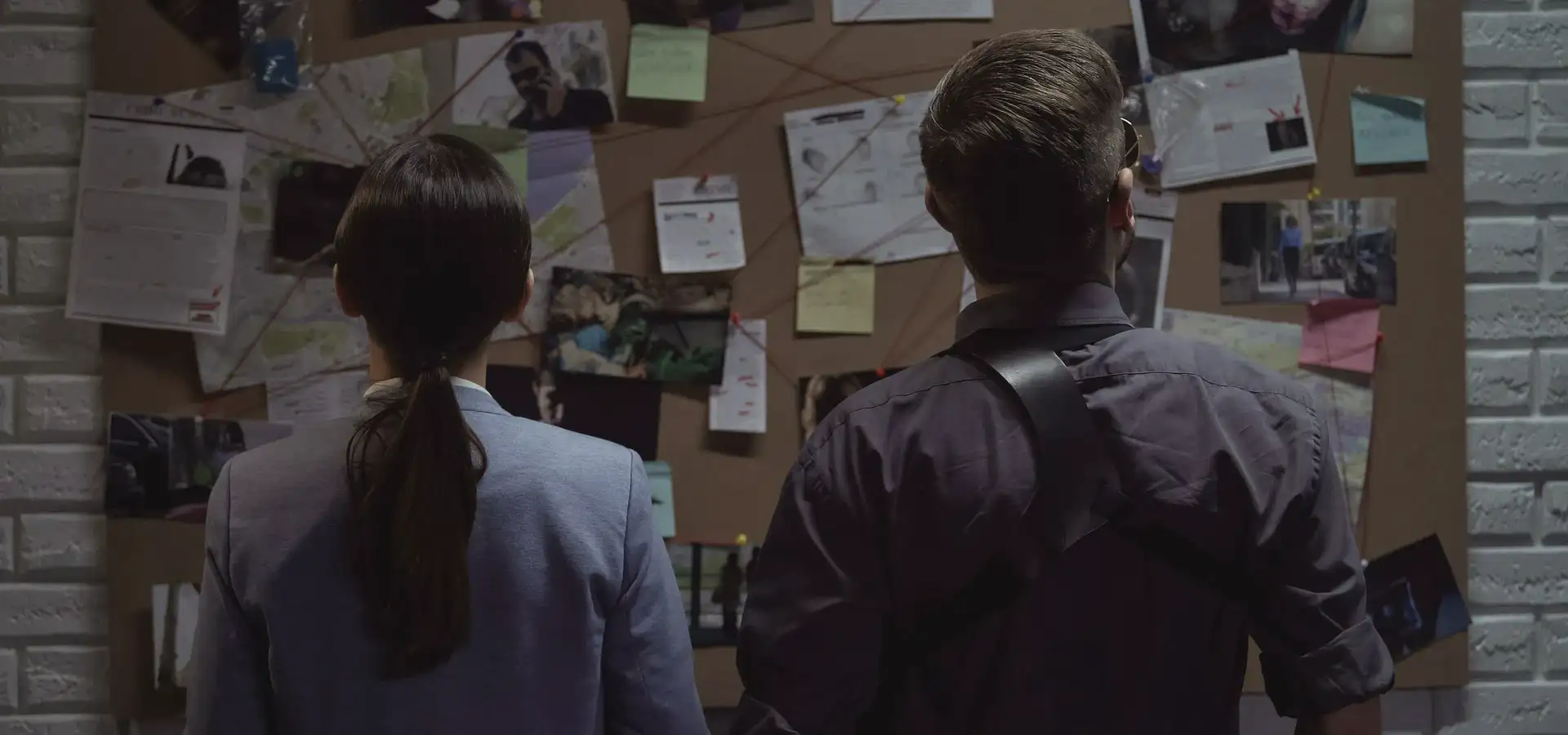 detektywi przed tablicą korkową